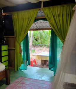 帕克拉Jungle Tent 3x3, Latino Glamping & Tours, Paquera的一间卧室配有绿色窗帘和桌子