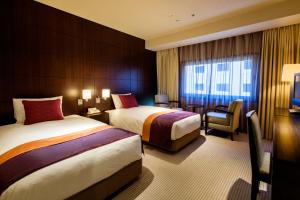 东京爱德蒙大都市东京酒店的酒店客房,配有两张床和椅子