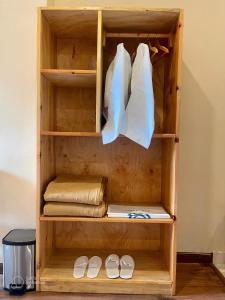 帕罗Shomo Chuki Resort的配有白色衣服和鞋的木制衣柜