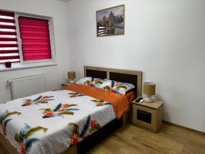 锡比乌Apartament Elena的一间卧室配有一张带橙色棉被的床