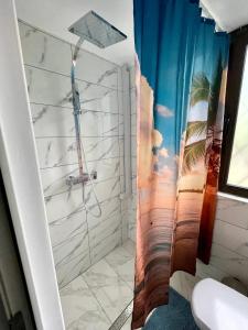 布加勒斯特Vis-a-Vis Studio - Gara de Nord的浴室设有海滩壁画和淋浴。
