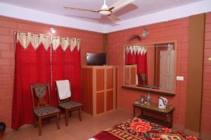马迪凯里Sai Home Stay的一间卧室设有红色的墙壁、红色的窗帘和电视