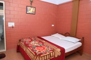 马迪凯里Sai Home Stay的卧室设有红色砖墙和一张床