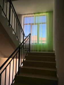 乔尔蓬阿塔Гостевой дом Крылья的一条带绿色墙壁和窗户的楼梯