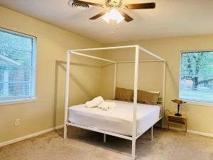 杜兰特The Lil' Yellow Door8的卧室配有白色的天蓬床和风扇