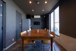 增田ゲストハウス＆カフェ　ハレテル的一间会议室,配有木桌和椅子
