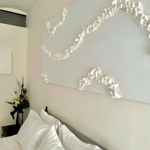 布鲁塞尔Les Lofts d'Artistes的卧室配有白色墙壁,床上方设有链条