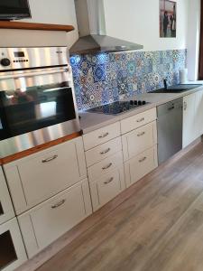 波鸿Haus Oveney的厨房配有白色橱柜和炉灶烤箱。