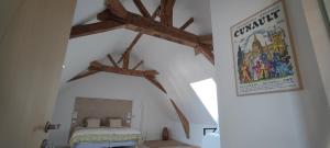 Saint-Mélaine-sur-AubanceLa Demeure de l'Aubance的卧室设有木横梁天花板。