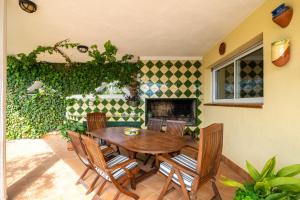 拉梅特拉·德·玛尔Vila Roser的庭院设有木桌、椅子和壁炉。