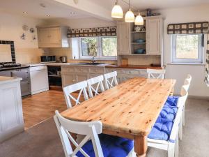 安布尔塞德Rawfell的厨房配有木桌和白色椅子