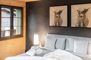 格施塔德Swiss Hotel Apartments - Gstaad的卧室配有一张壁挂着两个鹿头的床
