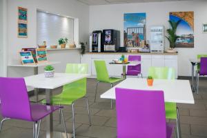 马赛Twenty Business Flats Marseille Timone的餐厅设有白色桌子、紫色和绿色椅子