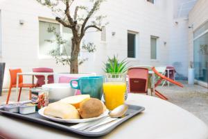 马赛Twenty Business Flats Marseille Timone的桌上的早餐食品和橙汁托盘