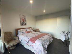 WaikawaMoana BnB, Waikawa Bay, Picton的一间卧室配有一张大床和一把椅子