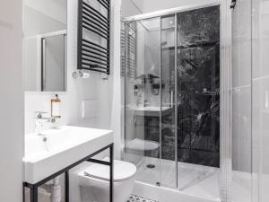 索波特Boho Rooms Sopot的带淋浴、卫生间和盥洗盆的浴室