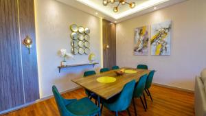 迪拜GOODWOOD SUITES HOMES VACATION的一间带木桌和蓝色椅子的用餐室