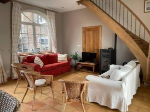 Frasnes-lez-GosseliesCottage entier : 6 à 8 personnes - La Ferme du Try的客厅配有红色的沙发和椅子