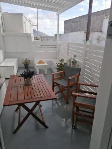阿克罗蒂里Santorita Suites的庭院配有木桌和两把椅子