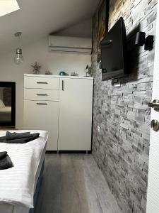 北马马亚-讷沃达里MG Mamaia North Villa的卧室配有1张床和1台砖墙电视