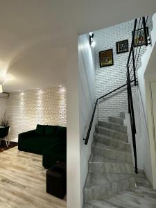 北马马亚-讷沃达里MG Mamaia North Villa的客厅设有楼梯和绿色沙发