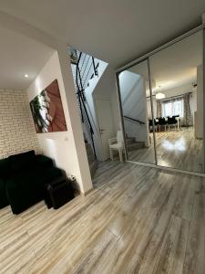 北马马亚-讷沃达里MG Mamaia North Villa的客厅配有黑色沙发和大镜子