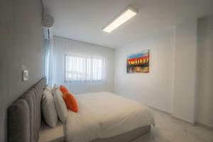 安曼Al Kawther Hotel Apartments的白色卧室配有床和沙发