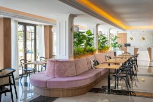 伊维萨镇Ocean Drive Ibiza的餐厅设有紫色的沙发和桌椅