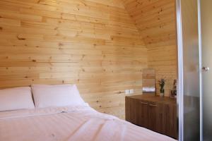 TrnicaMountain house Korab Trnica的一间带木墙的卧室和一张位于客房内的床
