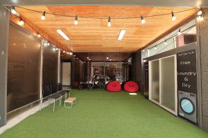 庆州Stay RomanticTrip_Hostel的一间位于大楼内的大型客房,铺有绿色地毯。
