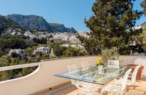 卡普里Oliveto Capri apartments的美景阳台的玻璃桌椅