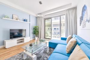 拉斯阿尔卡麦Luxury 1BR Beachfront Apartment Marjan Island的客厅配有蓝色的沙发和电视