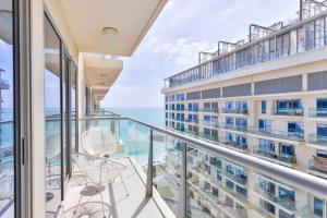 拉斯阿尔卡麦Luxury 1BR Beachfront Apartment Marjan Island的阳台配有椅子,享有海景。