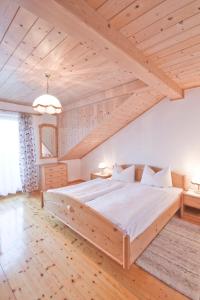 阿特湖畔施泰因巴赫哈斯保尔公寓式酒店的卧室设有一张木制天花板上的大床