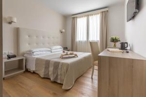 阿尔盖罗伽泰罗尼亚酒店的酒店客房配有一张床铺、一张桌子和一张书桌。