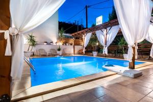 尼亚普拉莫斯吉普斯度假酒店的白色窗帘的酒店游泳池