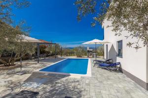 利纳迪奇Villa LIO with private pool的房屋旁的游泳池配有椅子和遮阳伞