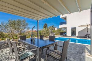 利纳迪奇Villa LIO with private pool的一个带桌椅的庭院和一个游泳池