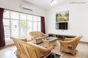 马六甲De Harmony Stay的客厅配有椅子、沙发和电视