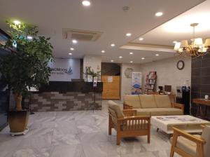 西归浦市SH Jungmoon City Stay的一间商店的大堂,配有沙发和椅子