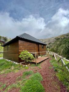 丰沙尔Mountain Eco Shelters 2的木屋,在田野上设有长凳