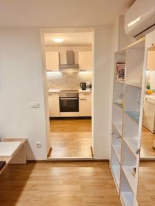 卢布尔雅那Blue Sun的厨房配有白色橱柜和硬木地板。