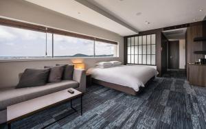 西归浦市SH Golden Tulip Seongsan Stay的酒店客房,配有床和沙发