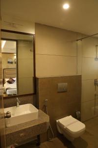 戈尔哈布尔Blisss Hotel Kolhapur的一间带水槽、卫生间和镜子的浴室