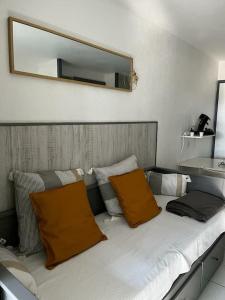莫列马阿Chez Mag et Jo的一张带两个橙色枕头和镜子的床
