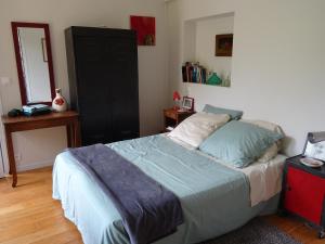 凯恩Chambre d'hôtes sur jardin acces PMR的一间卧室配有一张床和一个黑色橱柜