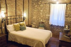 阿塞沃Casa Rural Las Martas的一间卧室设有一张床和砖墙