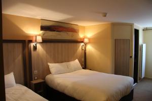 维伊尔勒比松洛奇酒店的酒店客房设有两张床和两盏灯。