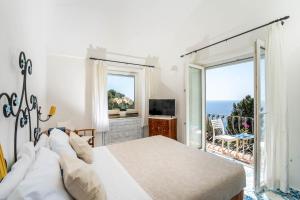 卡普里Oliveto Capri apartments的一间卧室配有一张床,享有海景