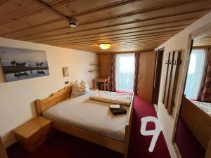 涅德劳莱顿霍夫旅馆的一间带一张床的卧室,位于带木制天花板的房间内